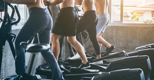 Sporty people running on treadmills machine in gym, Fitness exercise concept, group of young strong people training in modern gym, Shot focus on legs