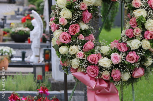 Ein Blumenkranz aus Rosen nach einer Beisetzung an einem Friedhof photo