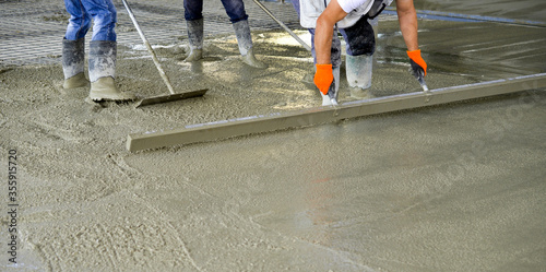 workers leveling concrete of a new building