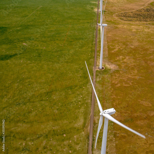 Aerial view of a wind farm on an agriculture farm with green crops
