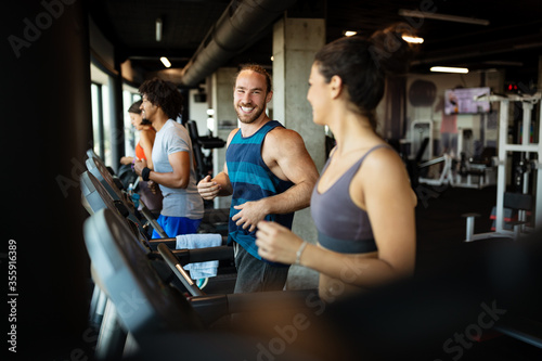 Group of young people running on treadmills in modern sport gym