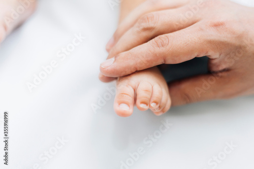 Baby feet in mother hands. Mom and her Child. Happy Family concept. Beautiful conceptual image of Maternity with film grain effect