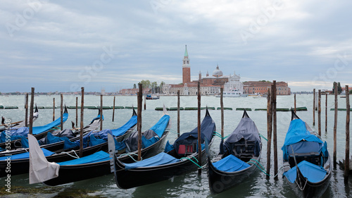A row of gondolas and Church of San Giorgio Maggiore on the Island of Saint Giorgio Maggiore in the background, Venice, Italy © kentaylordesign