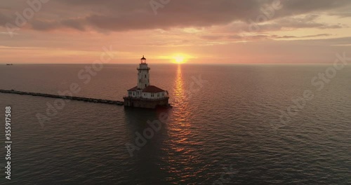 Aerial view of Chicago Harbor Lighthouse on Lake Michigan at sunrise. Warm orange sky photo