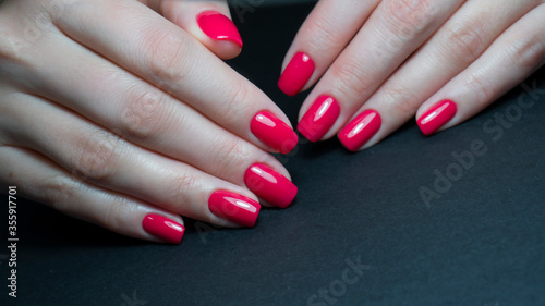 Close up view of female hands with red manicure. Classic red manicure, concept of beauty salon, nails polish.
