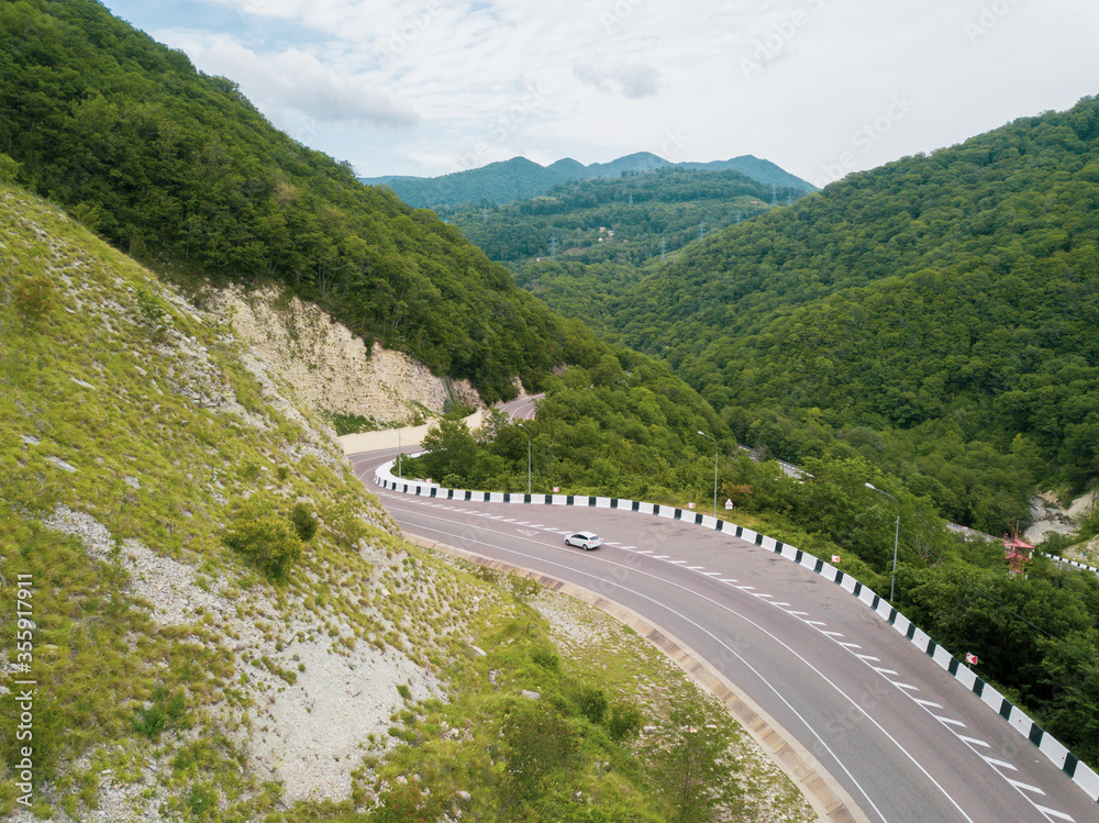 Mountain winding zig zag road. Top aerial view: cars driving on road from above.
