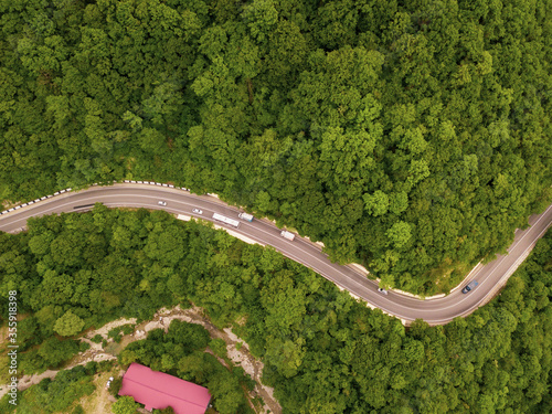 Fototapeta Naklejka Na Ścianę i Meble -  Mountain winding zig zag road. Top aerial view: cars driving on road from above.