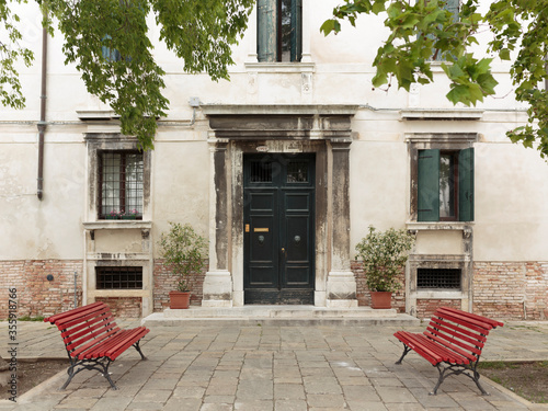 Red benches and building facade, Venice, Italy