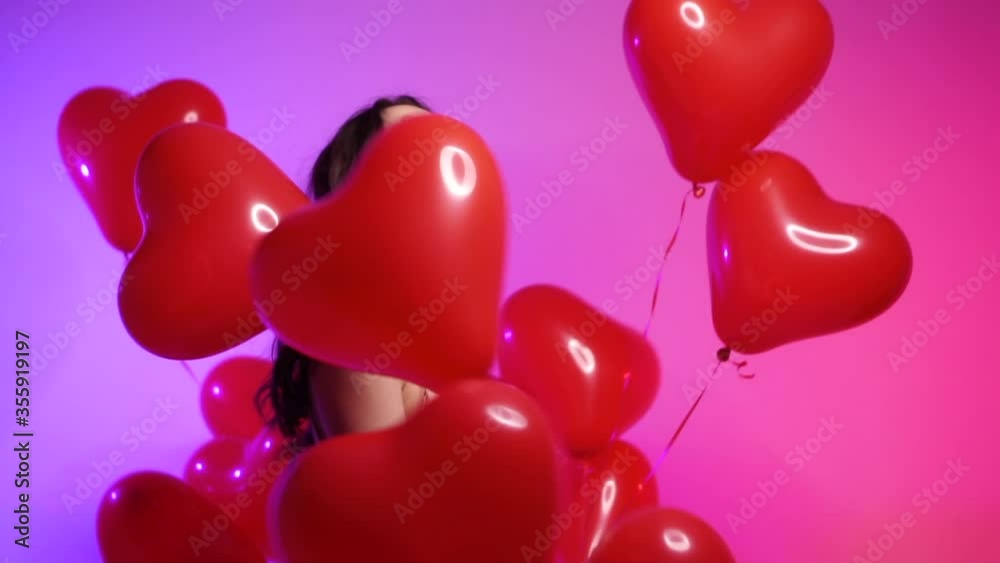 Happy young woman dancing with red heart-shaped balls. Slow motion. Happy young woman dancing with red heart-shaped balls. Slow motion.