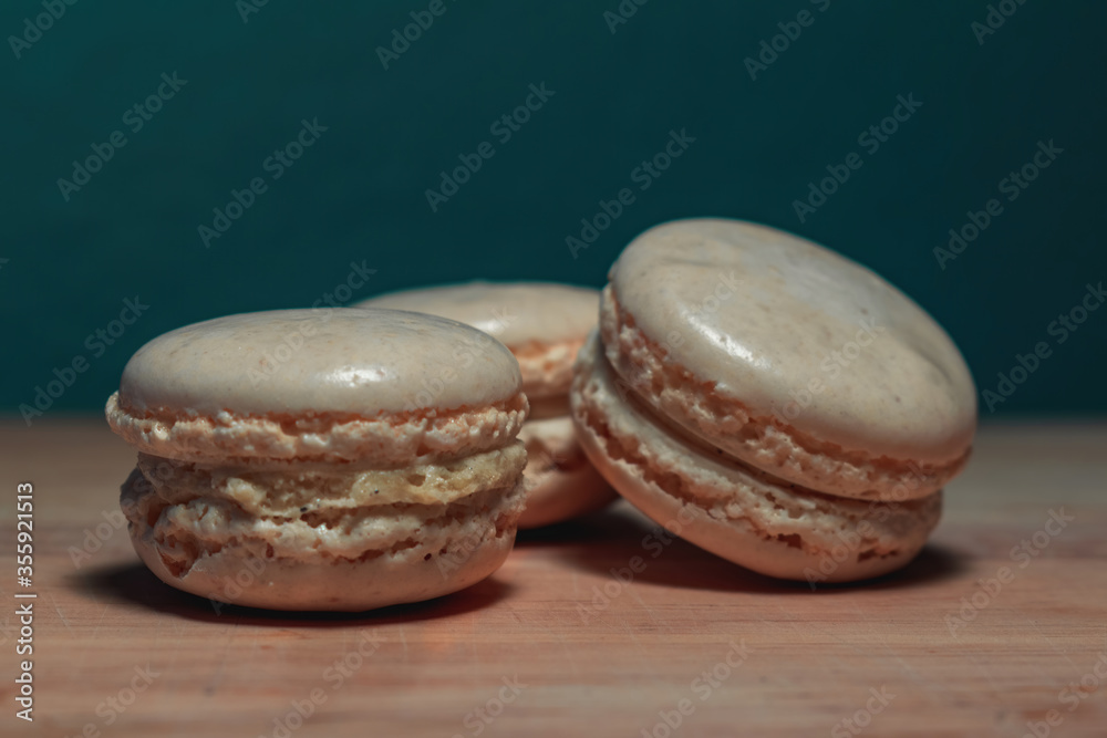 Three white macarons on wood with bleu background Three white macarons on wood with bleu background