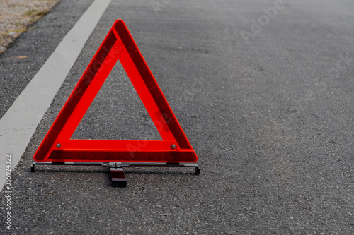 Emergency red warning triangle on the road sign with white traffic line © 168 Studio