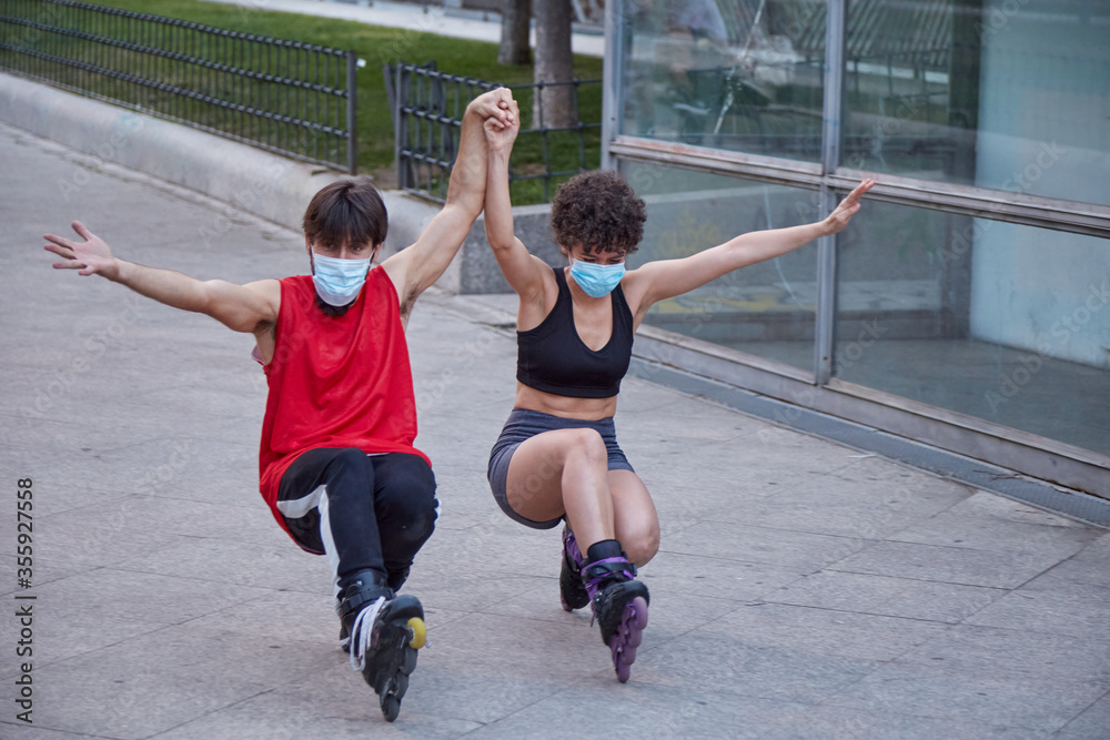 Couple skating on inline skates protected by face masks