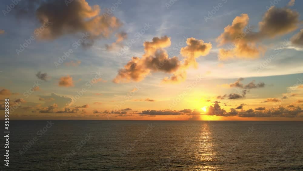4K UHD Aerial drone view Beautiful sunset over tropical beach with clouds In the middle of the sea