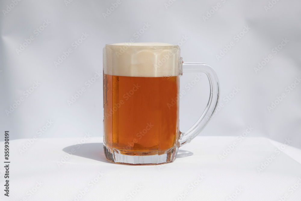 Poured semi dark beer with foam in a glass on white background. Poured semi dark beer with foam in a glass on white background.