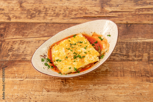 Delicious Italian lasagna on wooden background