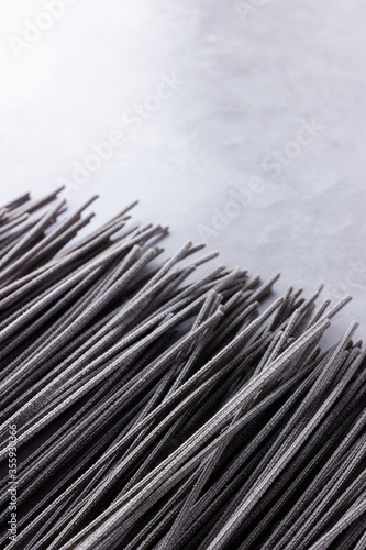 Black pasta on a gray background. Black spaghetti on cement background. Raw spaghetti with cuttlefish ink. Food background concept. Top view. Copy space