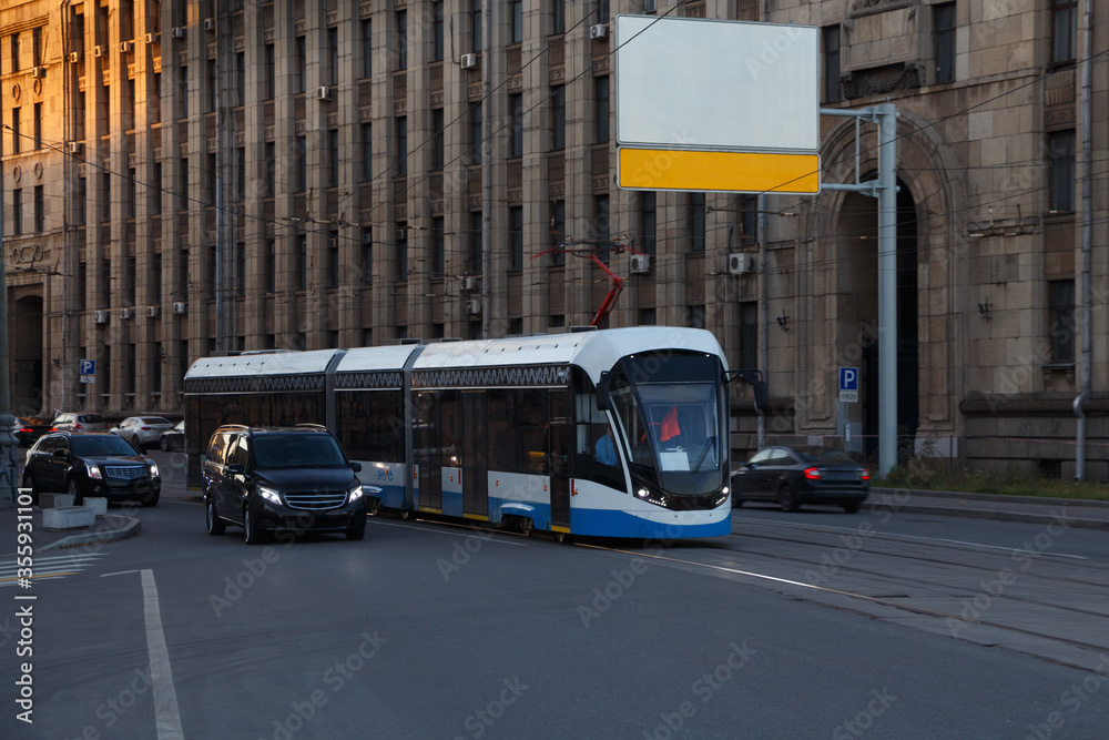 City evening landscape. Modern city tram, empty billboard, mock-up.