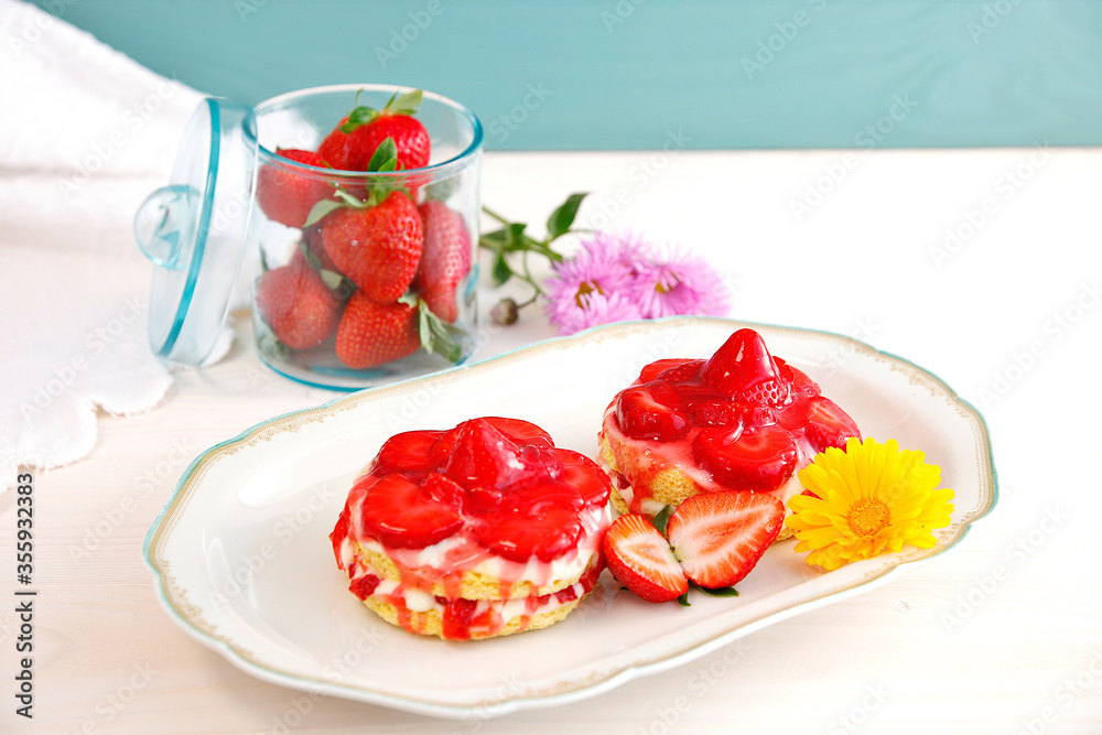 fresh strawberries in green glass, jar with tablecloth and flower background. Sweet strawberry natural fruits in Glass can. mini Strawberry and Yogurt cream sponge cake on plate. 