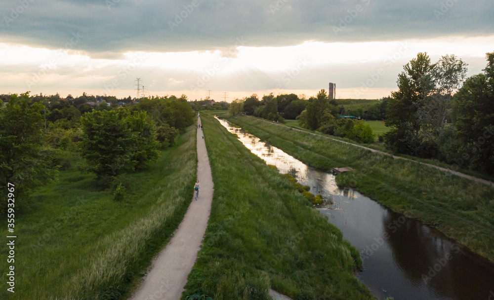 Obraz premium Path and river running to bright cloudy sunset