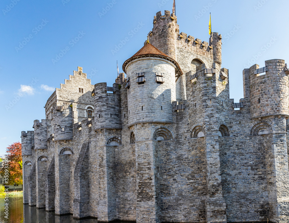 10th-century medieval moated castle Gravensteen view with towers and flags in Ghent, Belgium