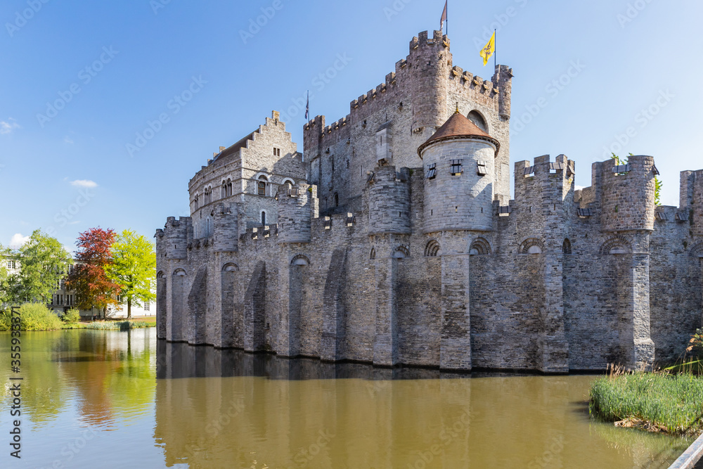 10th-century medieval moated castle Gravensteen view with towers and flags in Ghent, Belgium