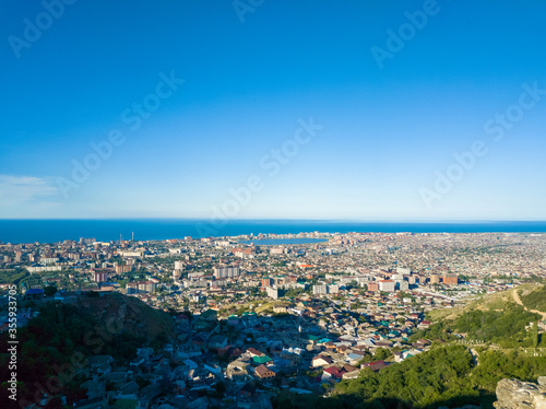 Landscape made from the mountain of Makhachkala city in Russia with a clear blue sky above the ocean without clouds.