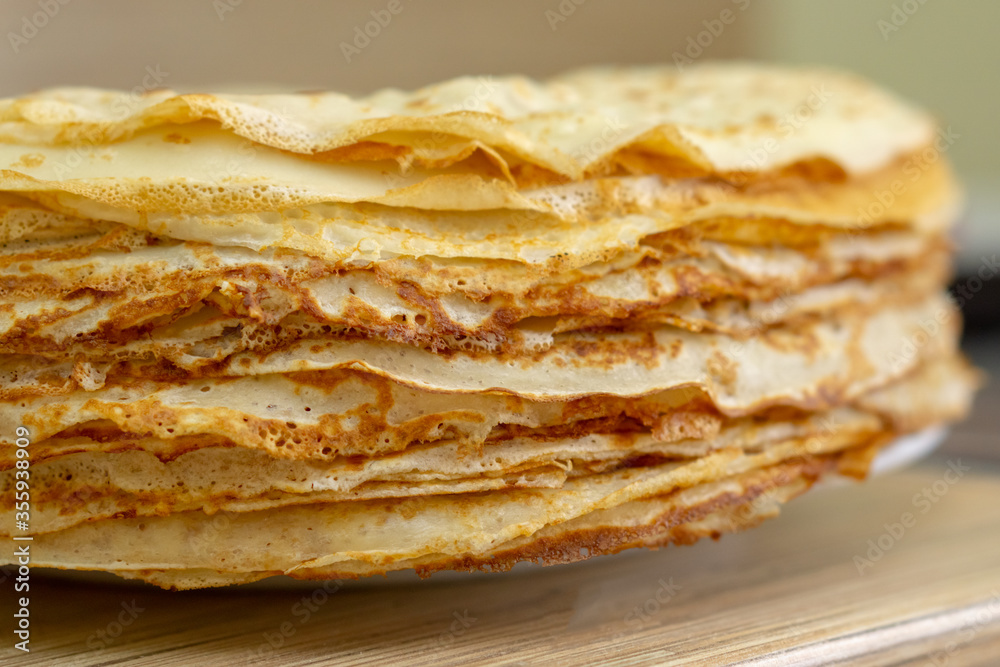 Russian pancakes are stacked on a plate Russian pancakes are stacked on a plate