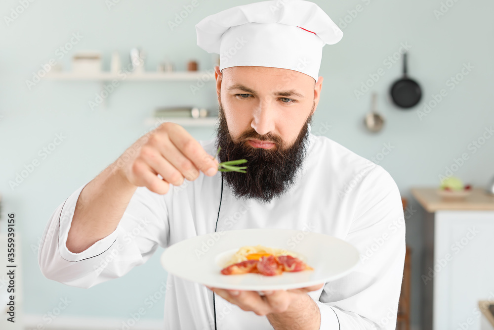 Male chef with tasty pasta carbonara in kitchen Male chef with tasty pasta carbonara in kitchen