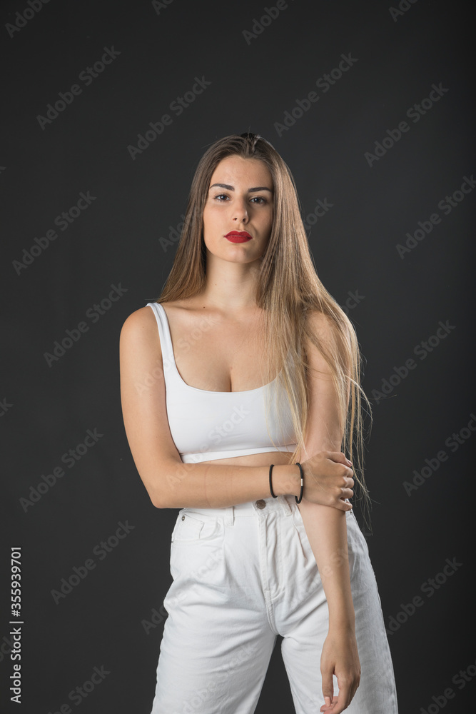 Modelo femenina joven posando en estudio fotográfico. Modelo femenina joven posando en estudio fotográfico.