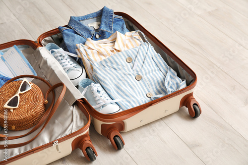 Open packed suitcase on woo...