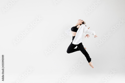 Female dancer in dance jazz poses in a jump on a white background. Jazz, modern, freedom, feelings, sport, figure, dance.