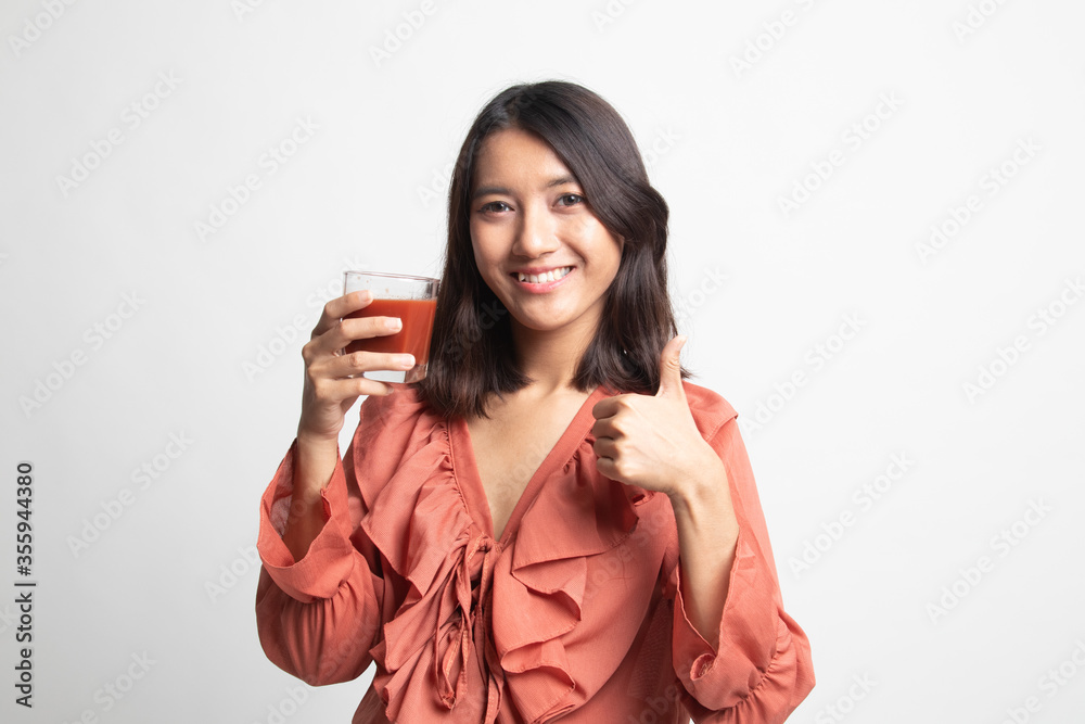 Young Asian woman thumbs up with tomato juice . Young Asian woman thumbs up with tomato juice .