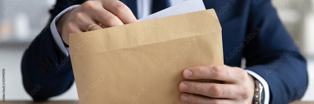 Horizontal panoramic view of businessman open envelope with postal paper letter in office, male employer or boss in formal suit get post paperwork document or correspondence at workplace - obrazy, fototapety, plakaty 