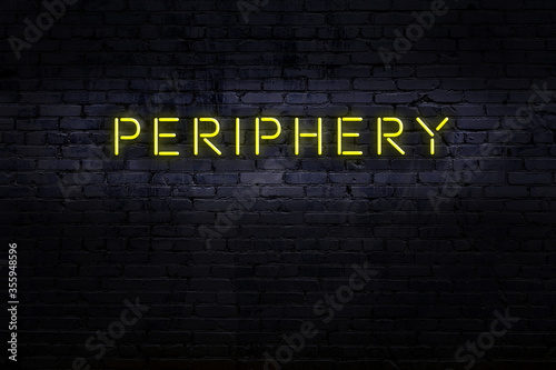 Night view of neon sign on brick wall with inscription periphery