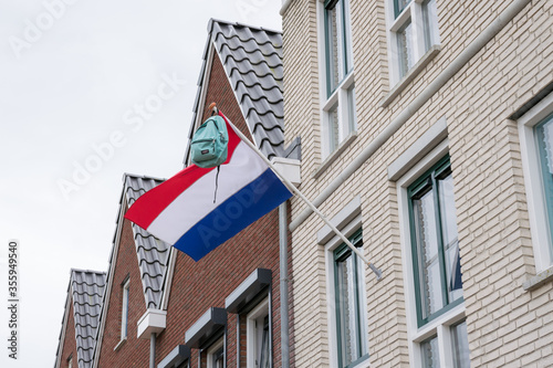 Backpack hangs from the Dutch flag. Tradition in the Netherlands when students have passed their exams.