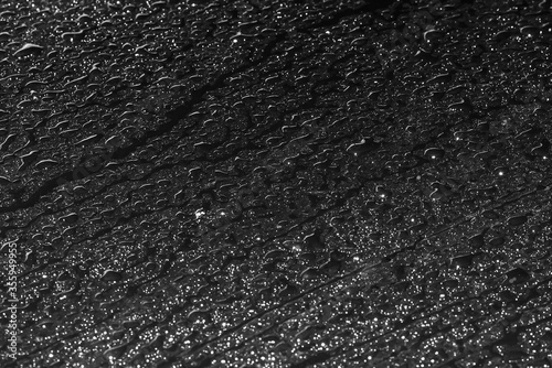 raindrops on a black shiny surface.Top view