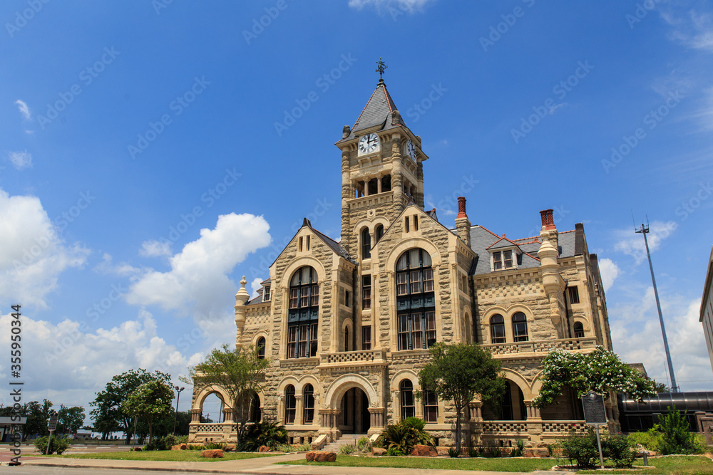 The Historical old Victoria County Courthouse built in 1892 looks like a castle. It stands next to De Leon Plaza on the main square in Victoria, Texas.