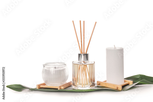 Reed diffuser and candles on white background