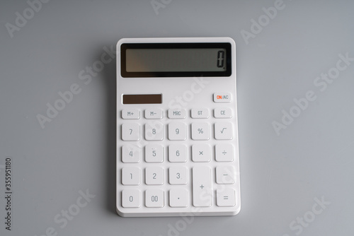 White calculator on grey background for education & business concept