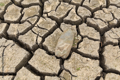 Εκτύπωση καμβά The bottom of a pond or lake during a severe drought exposed an old water bottle on the bottom
