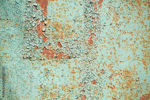 old rusty garage wall with peeling green paint. high humidity spoils the paint on the metal. abandoned destroyed room