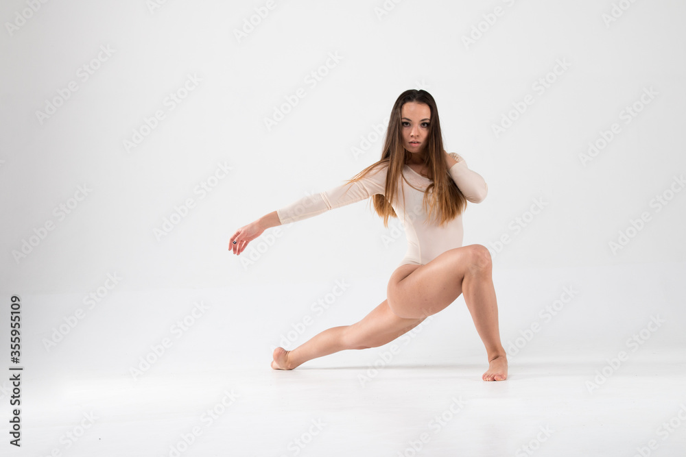 Female dancer in stretching beautiful pose on a white background. Art, style, background, elegant, expensive, luxurious, modern, ballet pas.