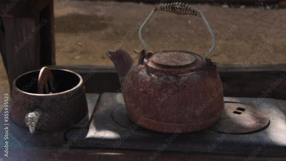 Pan across a rusted water kettle, and antique cooktop. Pan across a rusted water kettle, and antique cooktop.