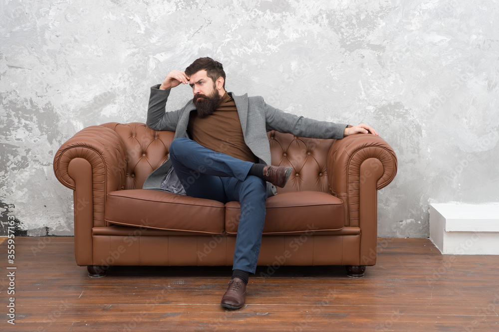 Beardy hipster. Serious hipster relax on sofa. Businessman with hipster beard. Barbershop or barbers. Hipster fashion trend. Business casual style. Menswear store Beardy hipster. Serious hipster relax on sofa. Businessman with hipster beard. Barbershop or barbers. Hipster fashion trend. Business casual style. Menswear store