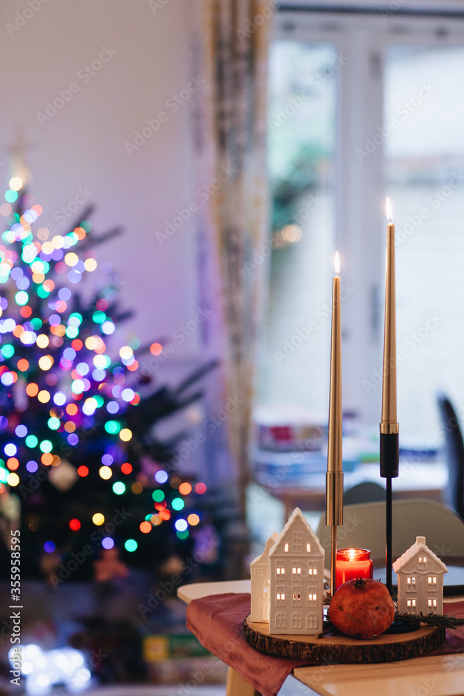 Naklejka premium christmas candles on the table, christmas tree decorations, festive interior