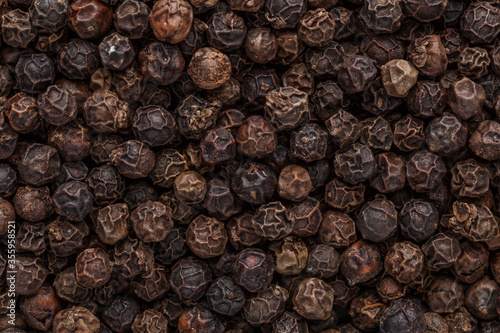Peppercorn background. Dry black pepper seeds. Top view. Flat design. Macro spice background