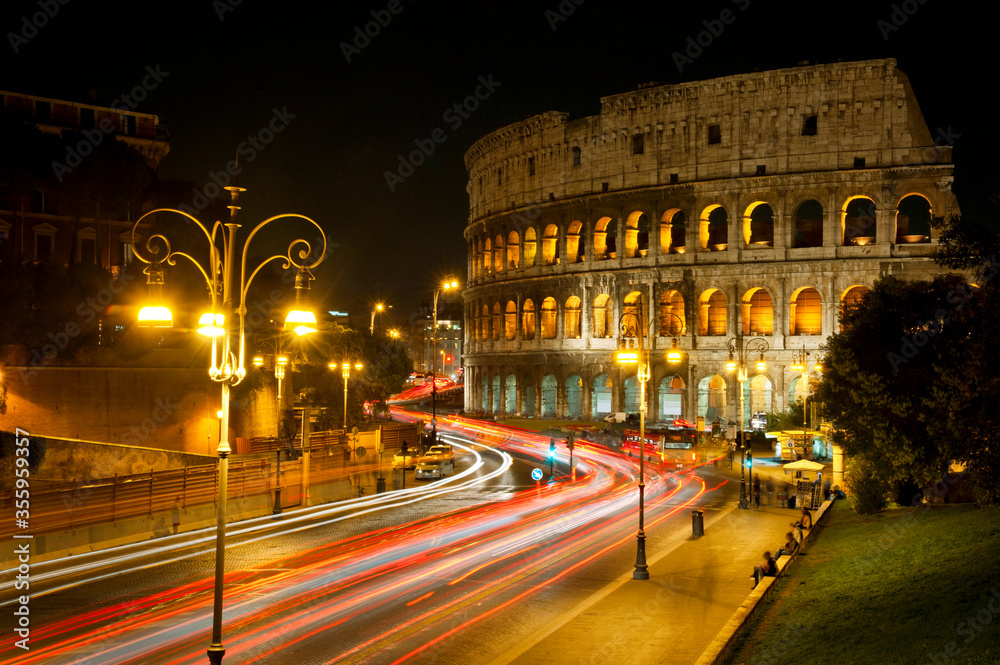 Coliseum in Rome at night and traffic light traces.