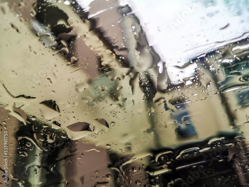 Waterdrops on the car window - blurred cityscape on the background