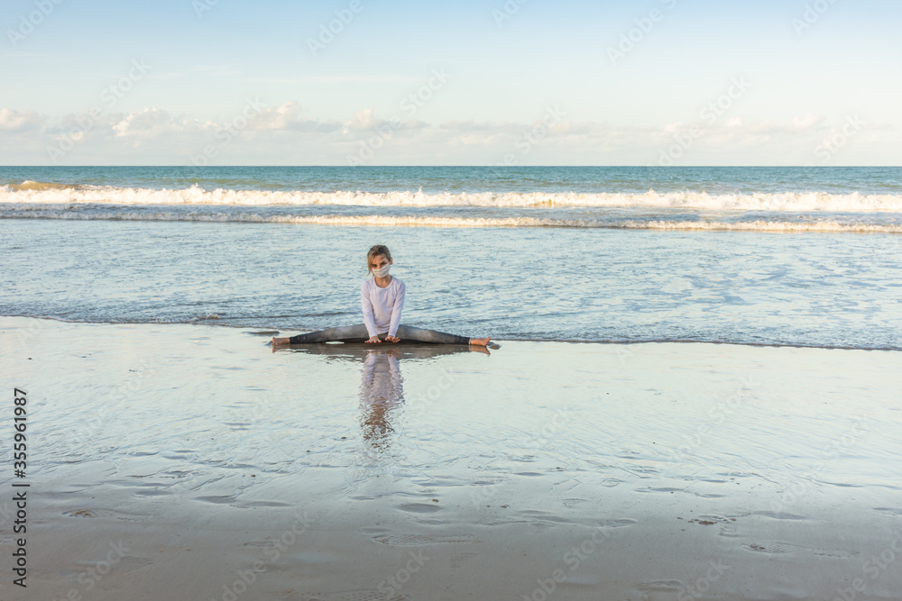Child meditating on the beach
