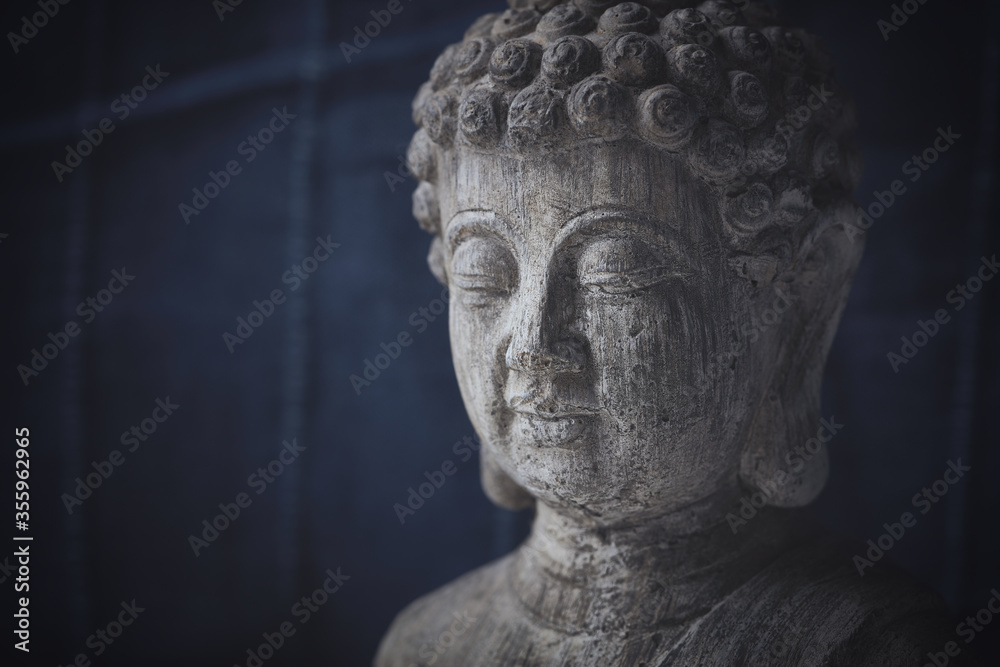 Meditating Buddha Statue on dark background. Copy space.